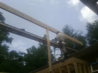Carpenter setting a ridge beam over a new addition frame — Ice Dam Removal by Roofing Brothers in Maineville