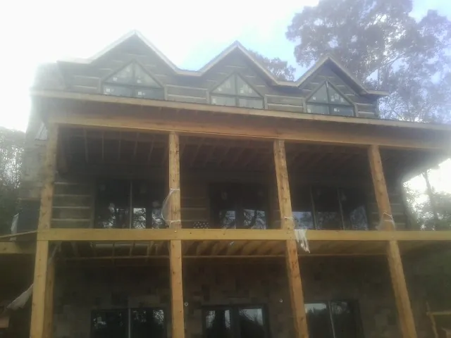 Dormers and porch framing on a large log home under construction — Roof Coating work by our crew in Maineville