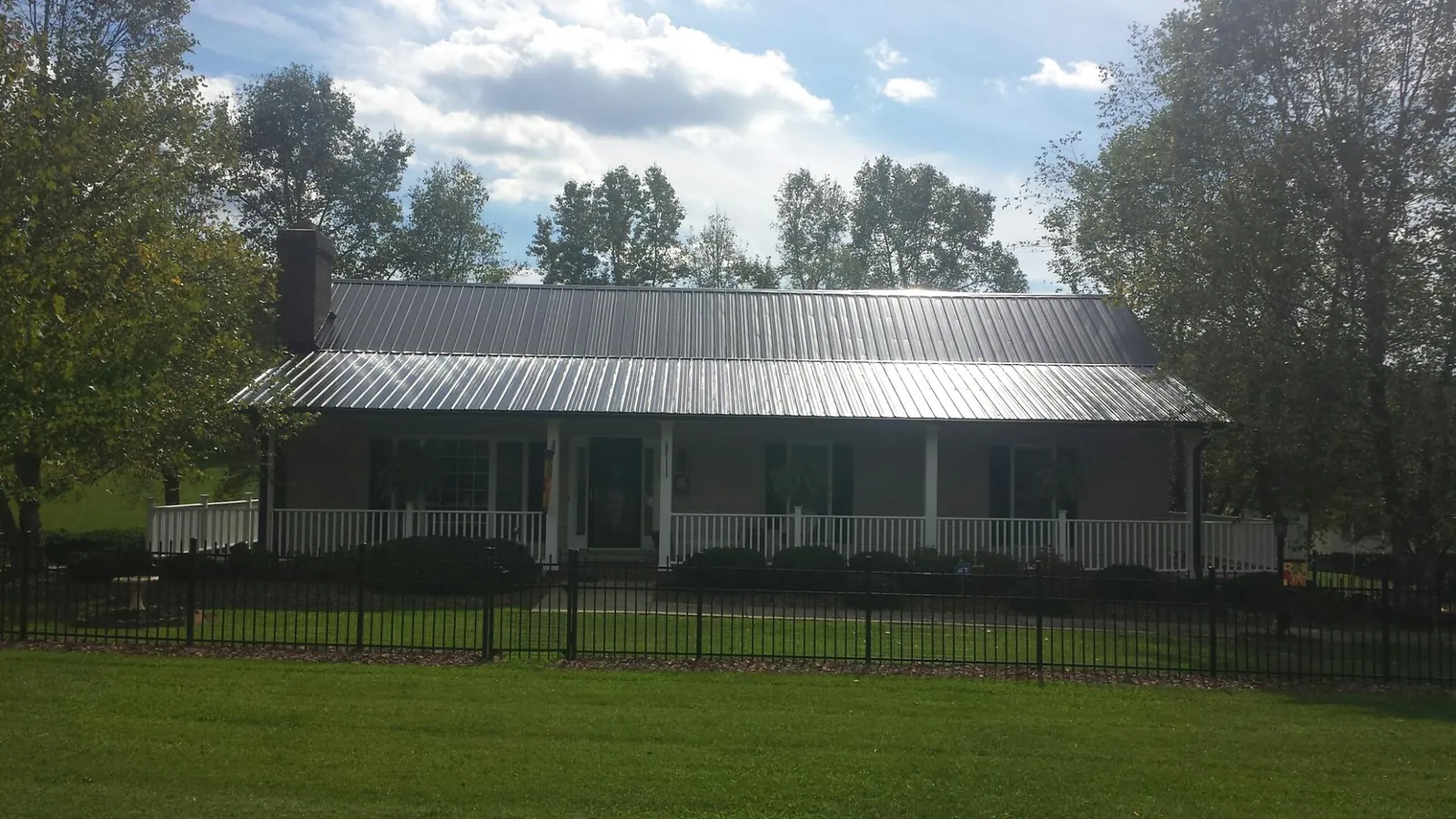 Gray metal roof on a brick ranch with a full width front porch — Gutter Guard Installation work by our crew in Maineville