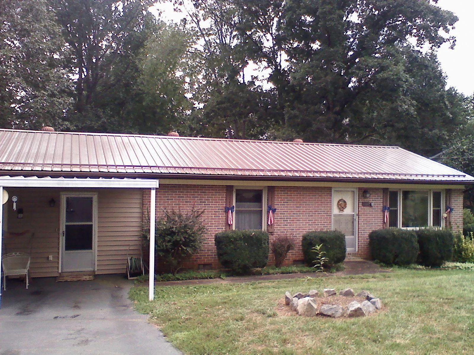 Bronze metal roof and carport on a brick ranch home — Roof Repair work by our crew in Maineville