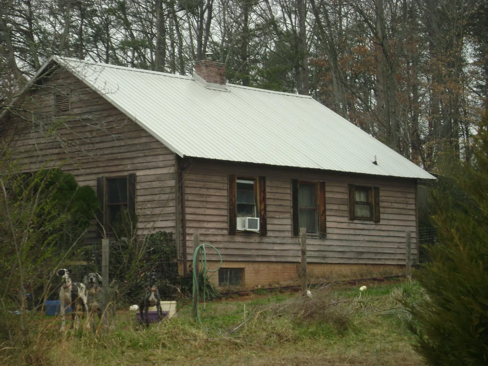White metal roof on an old wood sided farmhouse, from a Metal Roof Installation job in Maineville